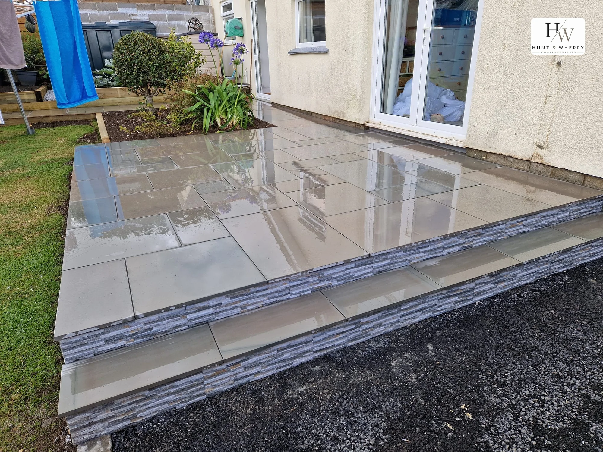 Polished porcelain patio on two levels with split-face stone clad risers