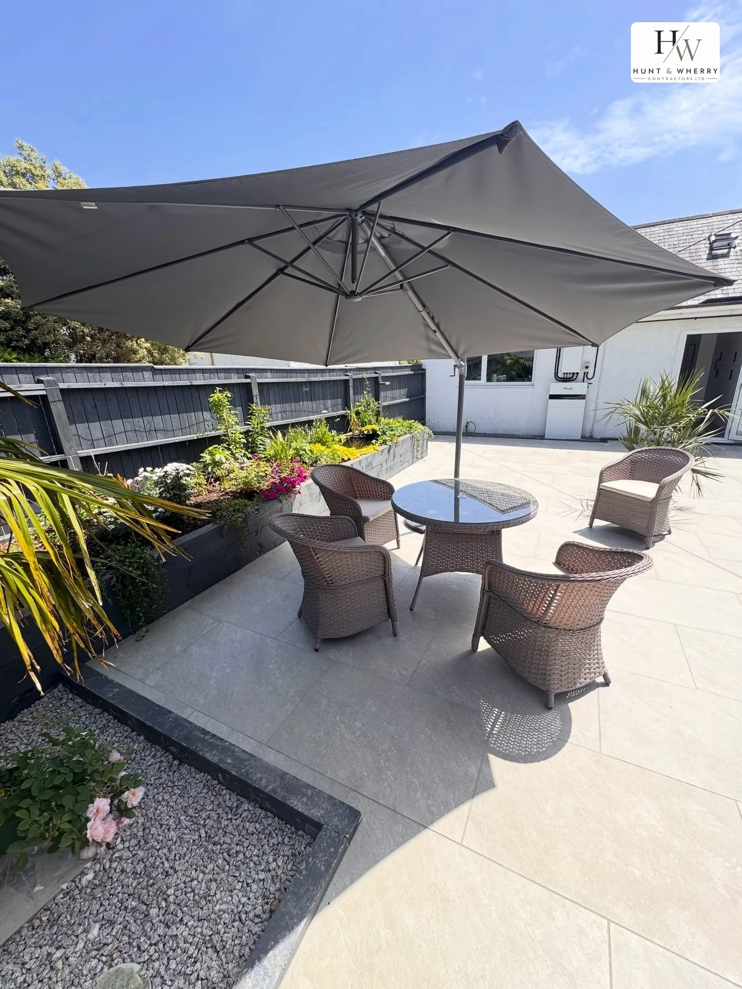 Light porcelain patio with garden furniture and parasol
