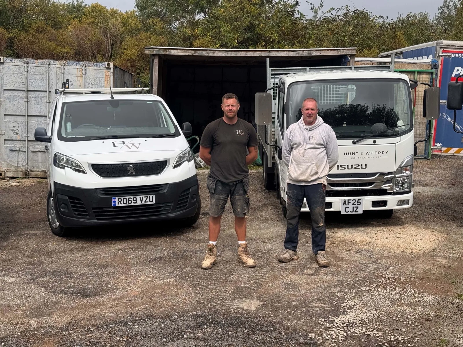 Aaron Hunt and Mike Wherry, the two owners of HW Contractors, in the yard in front of the liveried Peugeot van and Isuzu tipper