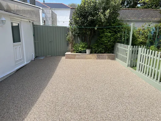 Buff resin bound driveway running to a fenced rear garden
